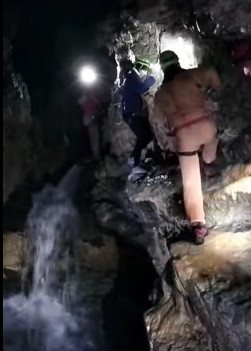 speleologi in grotta con acqua